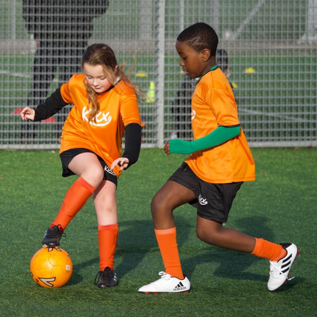 a young boy and girl playing football at Kixx football academy for kids