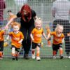 Toddlers playing football with coach during Kixx session