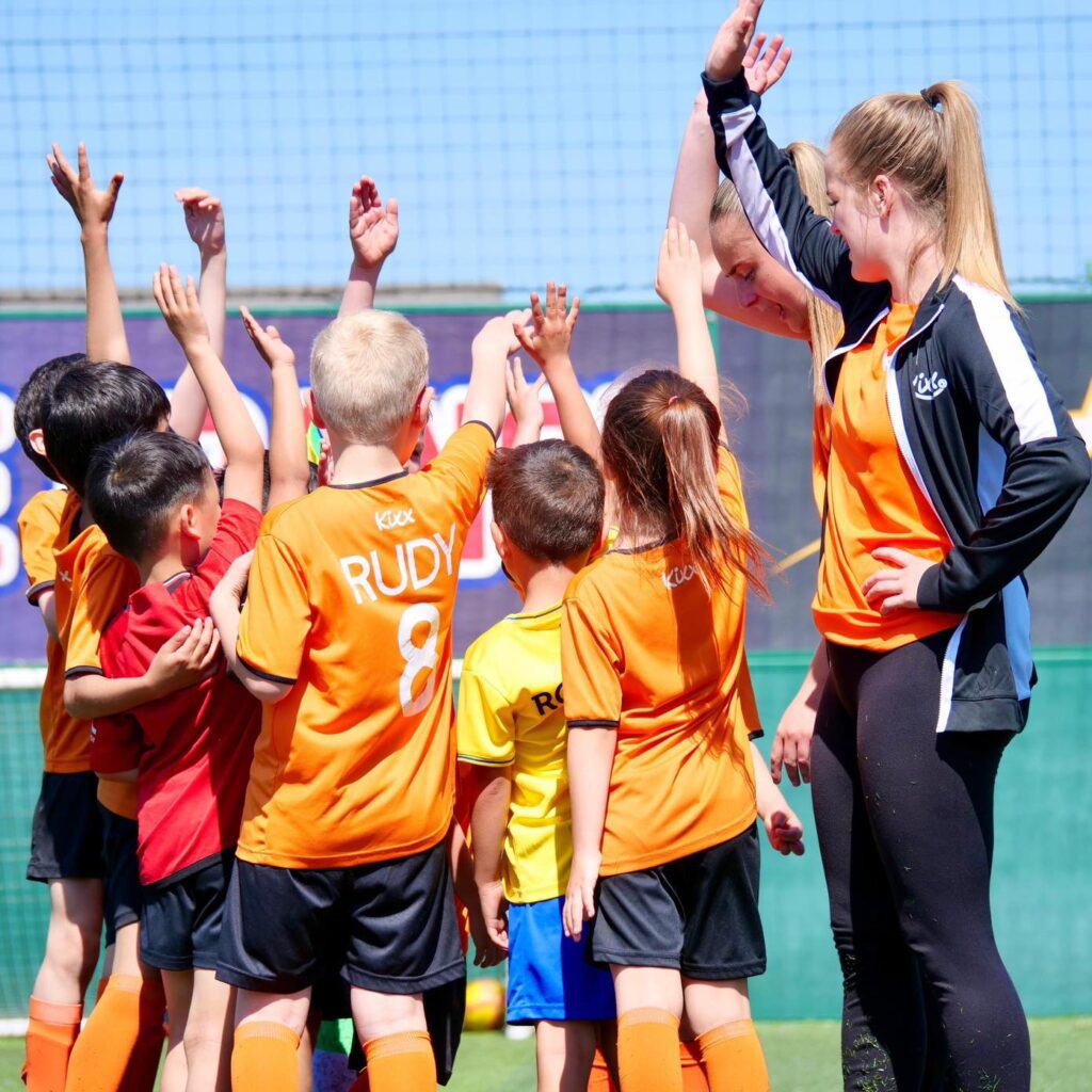 image of group high five for blog 4 Reasons To Choose Our Football Classes