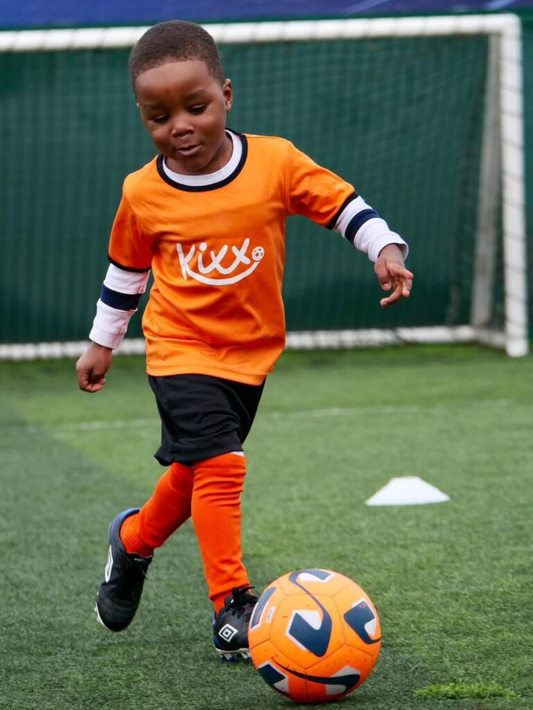 image of boy playing football for blog Why You Should Start Children's Football Classes In The Summer Holidays