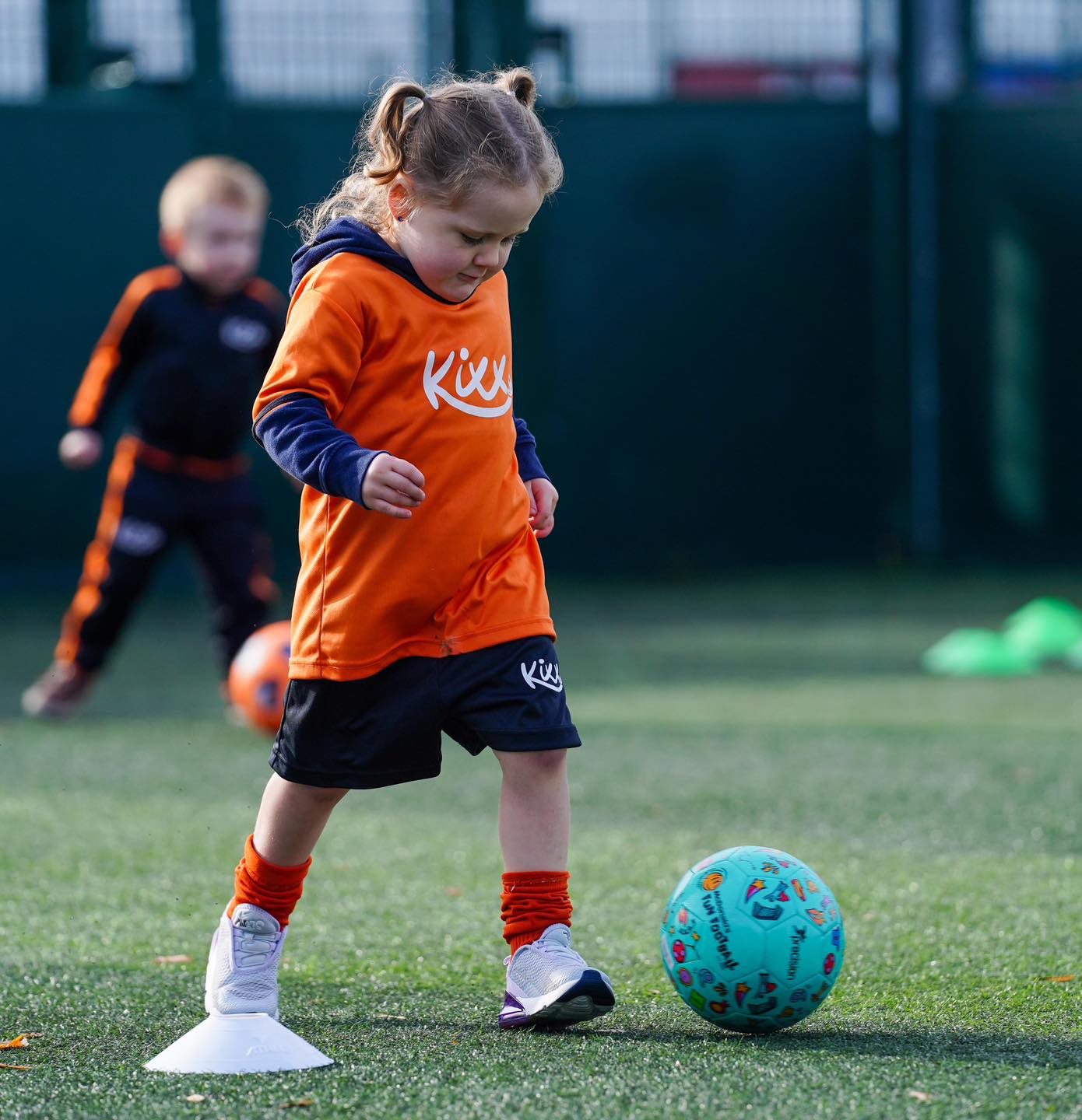 Image of little girl practicing dribbling for the blog 3 Ways To Perfect Your Passing In Football Lessons