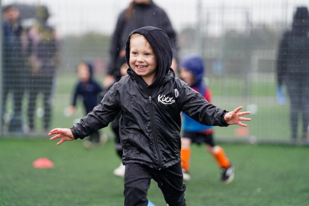 Image of boy at practice in the rain for the blog Exploring Benefits Beyond The Game 