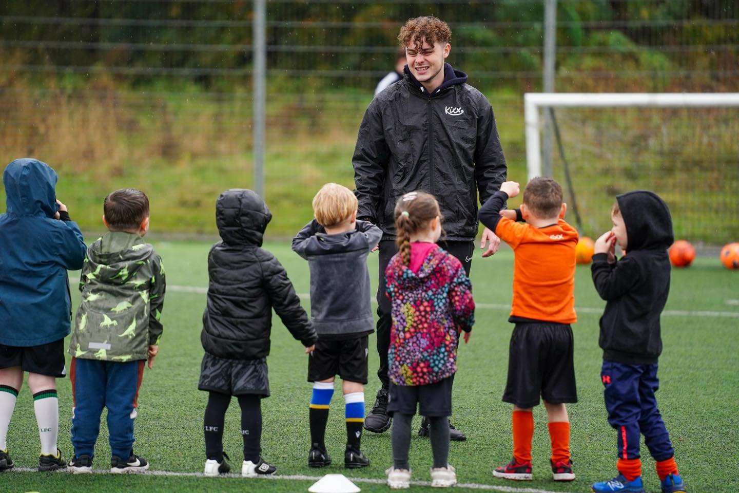 Image of Team Orange at practice in the rain for blog Exploring Benefits Beyond The Game