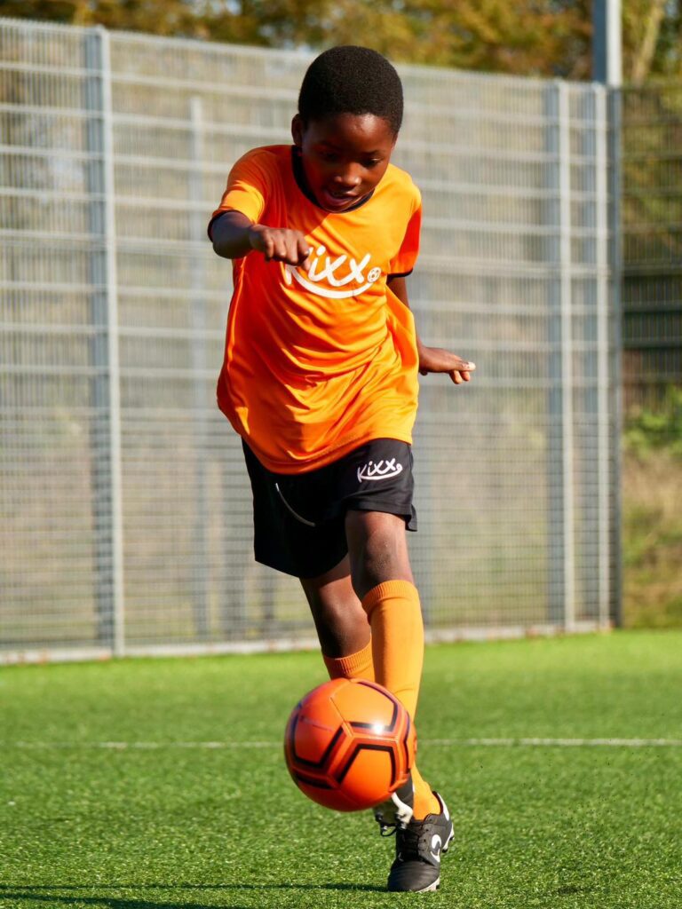 Image of boy practicing dribbling for blog Is 10 Years Old Too Old To Start Football Classes? 