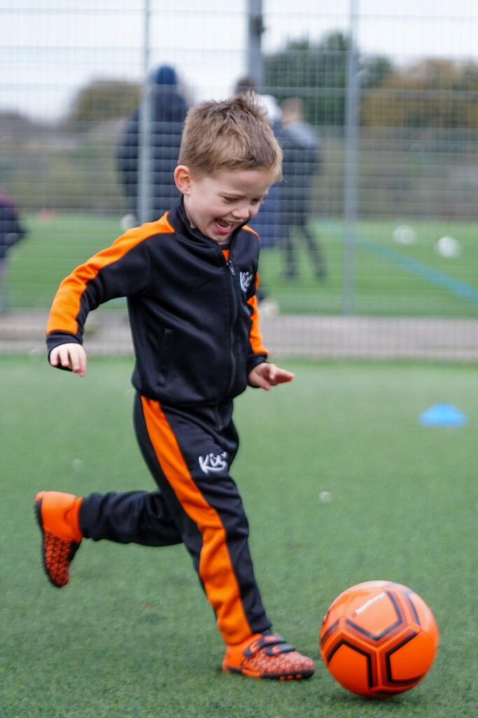 Image of a young boy practicing their dribbling for the blog How To Balance Football Classes And Schoolwork