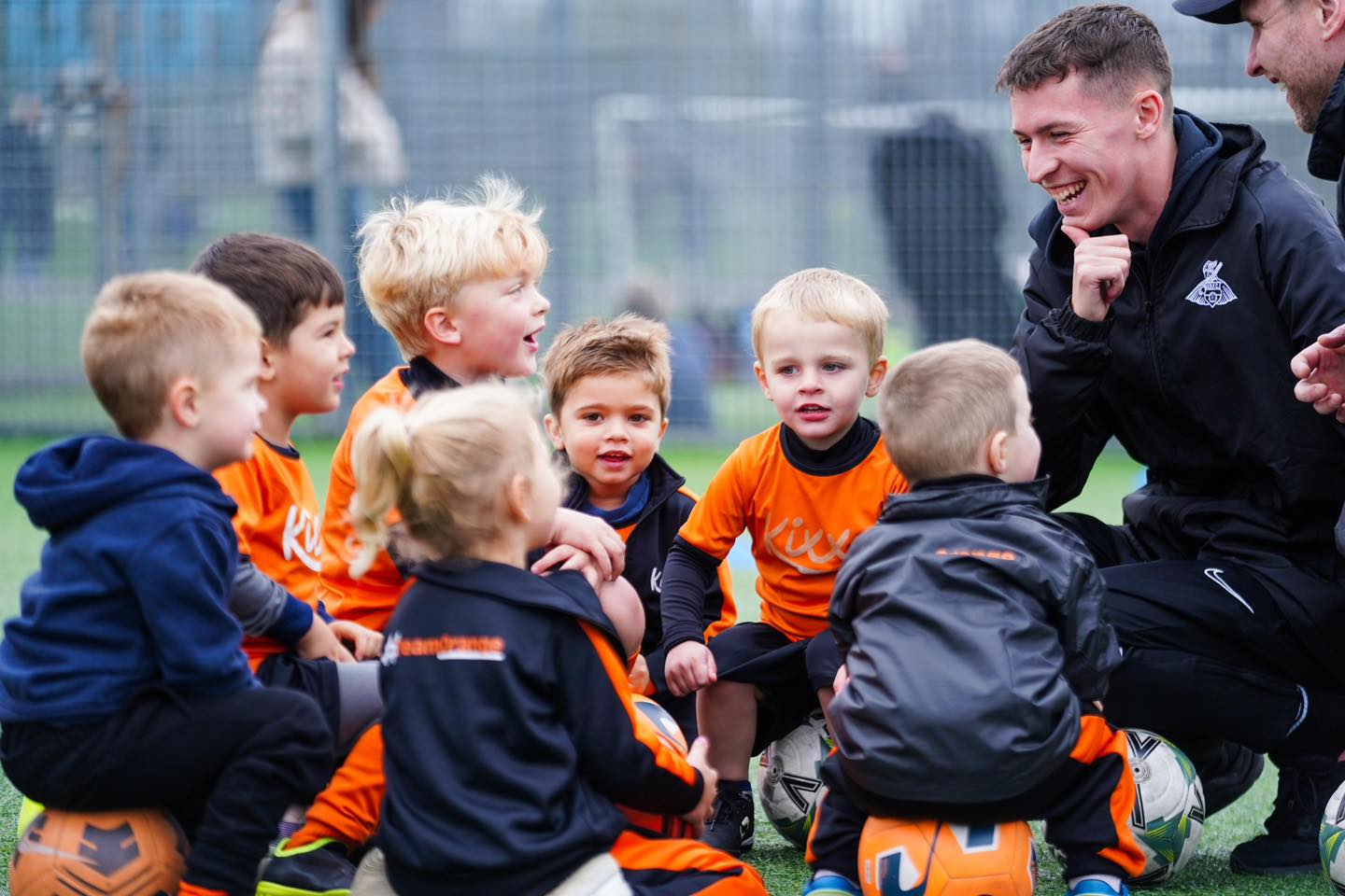 Image of a Kixx coach talking to a group of young players for the blog The 3 Signs Your Infant Is Ready To Join Football Classes