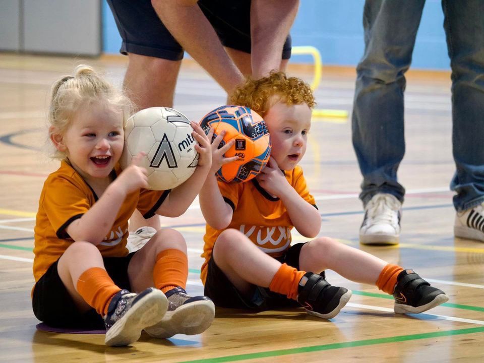 Image of two children holding footballs for the blog The Essential Skills Your 3-Year-Old Will Master In Football Training