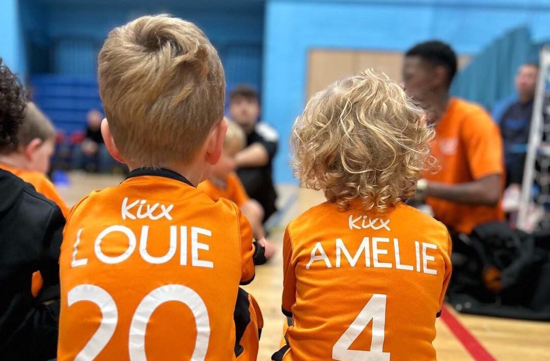 Image of two children listening to instructions at football training for the blog The Essential Skills Your 3-Year-Old Will Master In Football Training